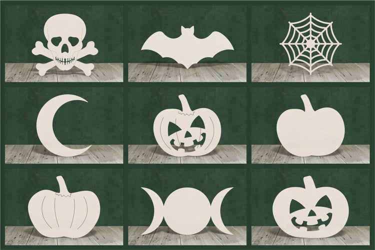 Selection of Halloween wooden shapes on a green background. Spooky pumpkins,bats, skulls and creepy spiders web.