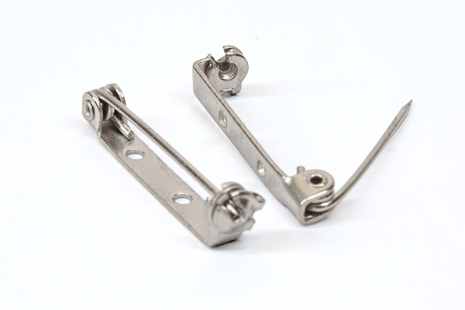 Two brooch pins on a white background. One pin open the closed