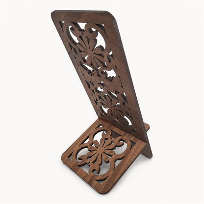 A dark brown wooden stand with intricate floral and butterfly cutout patterns on both the upright panel and the base, shown on a plain light background.