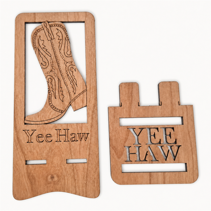 Two laser-cut wooden pieces on a white background. The larger piece features an engraved cowboy boot design and the text 'Yee Haw' at the bottom.