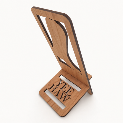 A wooden stand made from laser-cut cherry, featuring a vertical panel with a boot cutout and a base with 'YEE HAW'  cut through.
