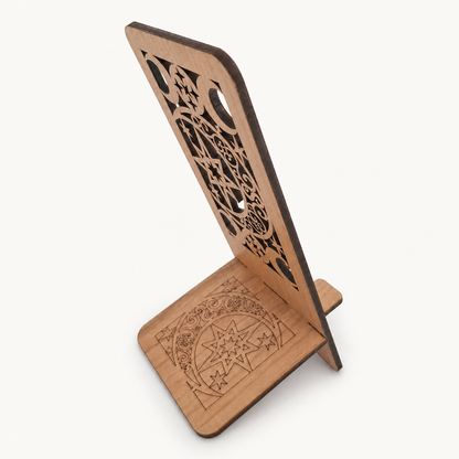 A wooden stand with intricate laser-cut patterns on the back panel and engraved geometric designs on the base, shown on a clean off-white background.