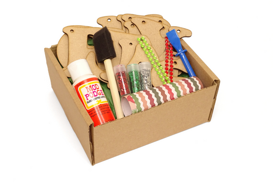 Cardboard box with craft supplies including a brushes, bottle of mod-podge, glitter, twine, coloured paper. On a white background
