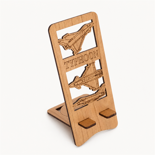 A wooden phone stand featuring laser-engraved fighter jets and the word 'TYPHOON', shown on a clean off-white background.