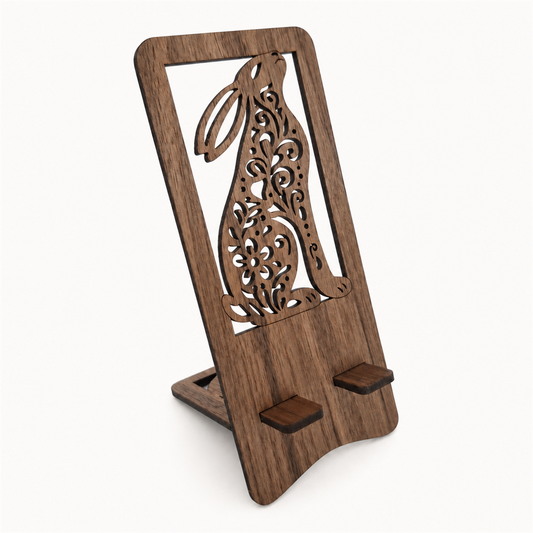 A wooden phone stand with a laser-cut rabbit/Hare with a cut through intricate design, shown on a clean off-white background.