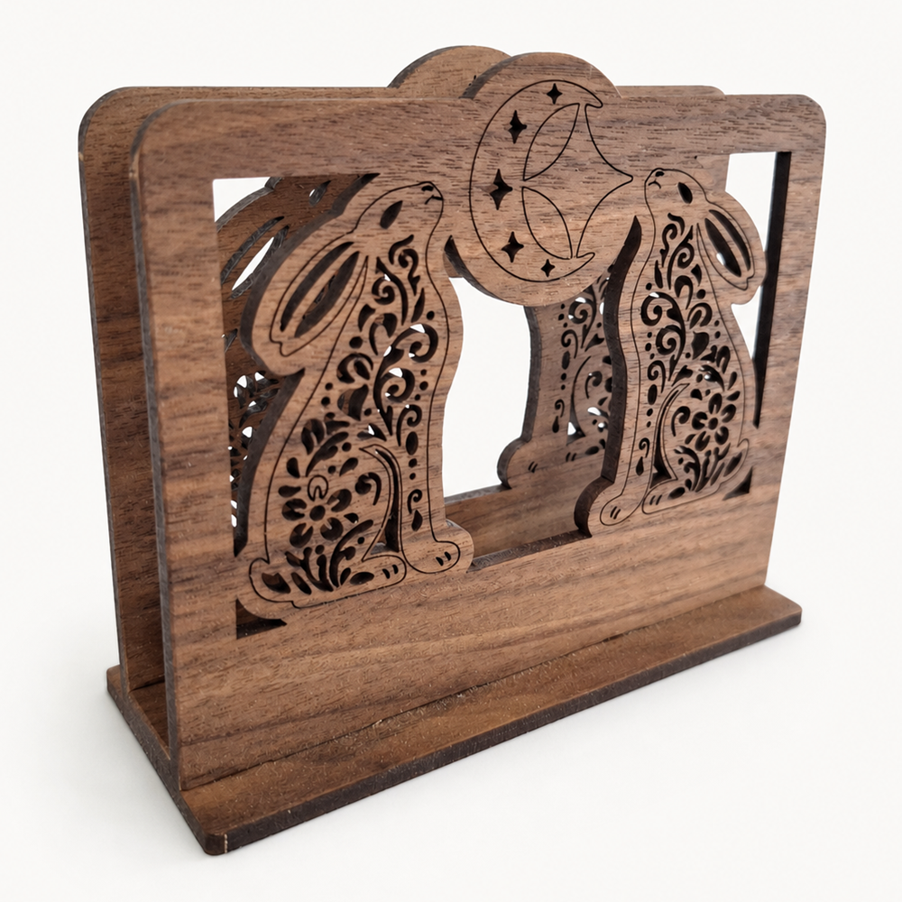 A walnut wooden decorative napkin holder with laser-cut rabbit and crescent moon motifs, shown on a plain light background.